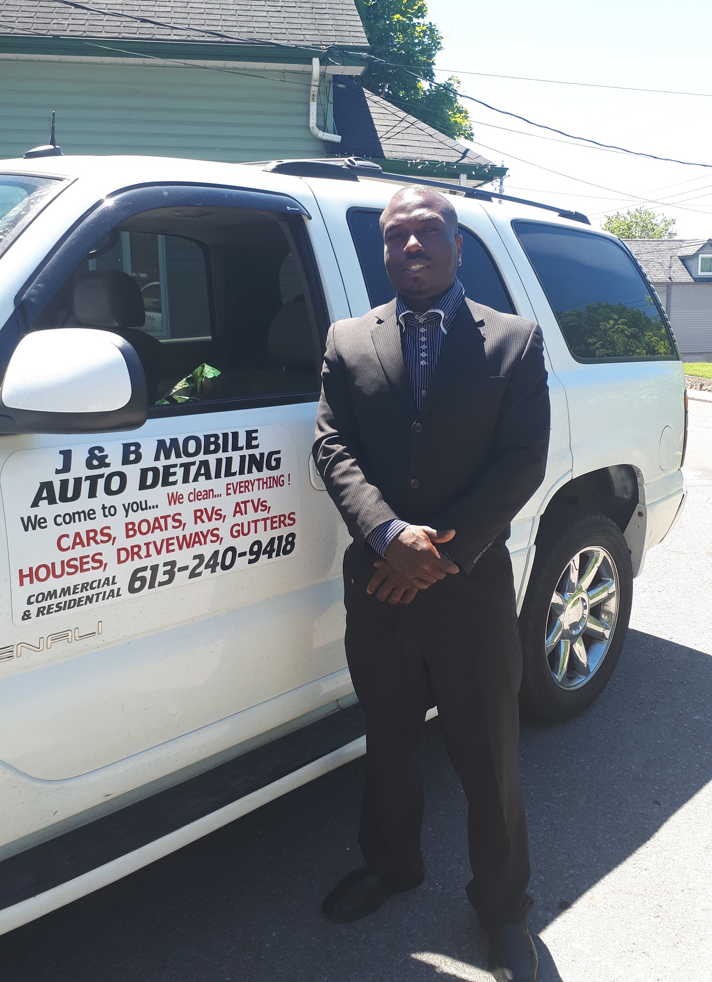A member of the J&B Mobile Auto Detailing team beside the company's branded service vehicle