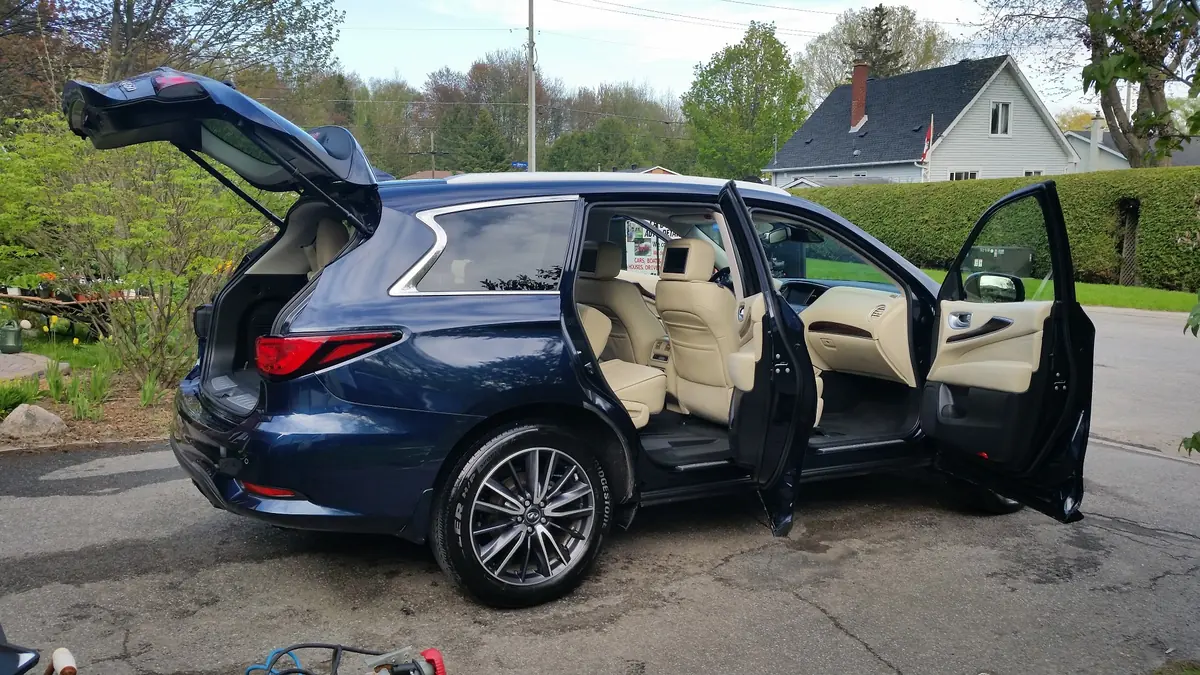 Blue SUV fully detailed, doors and tailgate open in a driveway