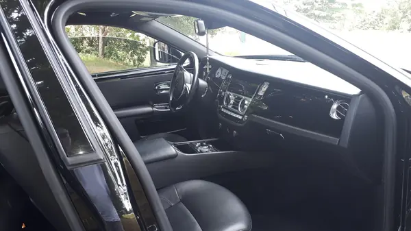 Detailed luxury sedan interior with black leather and polished wood trim
